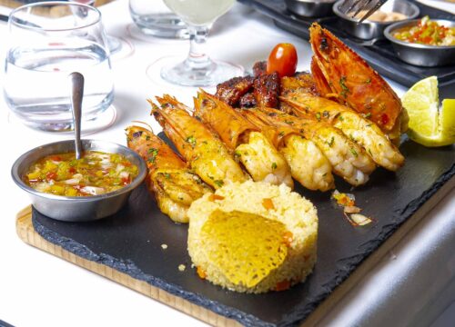 une assiette de nourriture avec des crevettes et du couscous sur une table