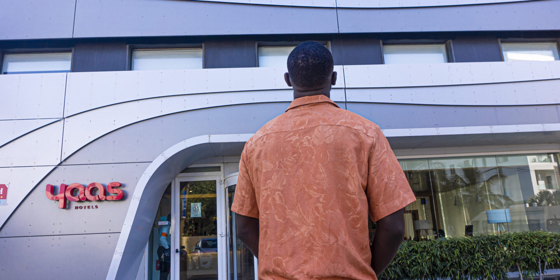 un homme se tient devant l'hôtel yaas