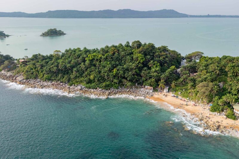 une vue aérienne d' une plage entourée d'arbres et d'eau