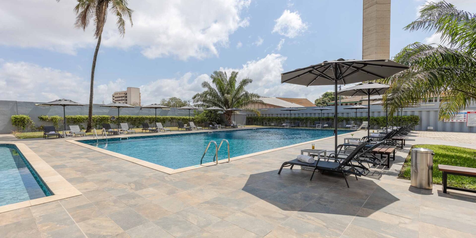 une grande piscine entourée d' ombrelles et de chaises longues