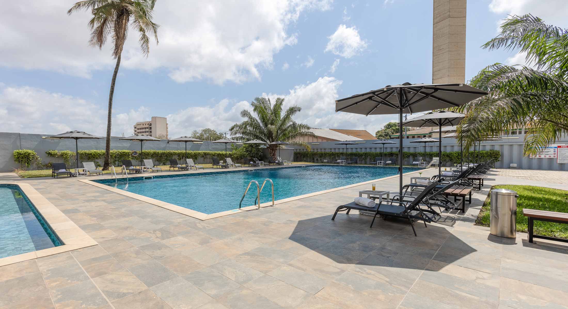 une grande piscine entourée d' ombrelles et de chaises longues