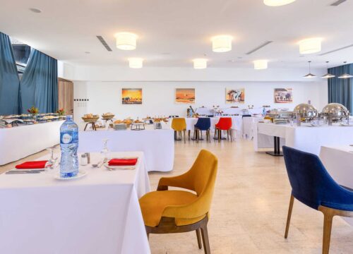 une salle à manger avec des tables et des chaises et une bouteille d' eau