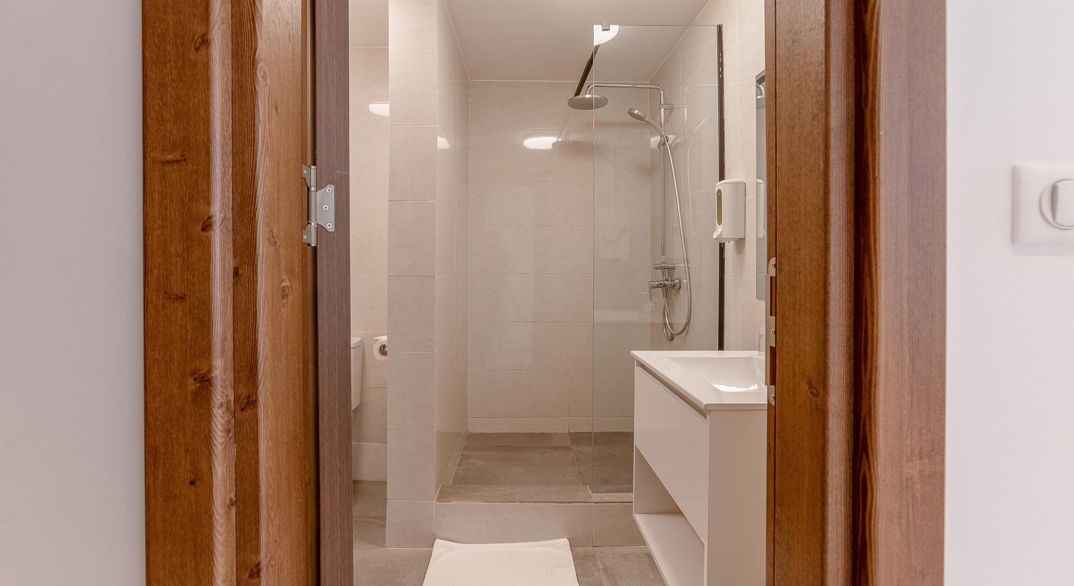 une salle de bain avec un lavabo et une douche en verre