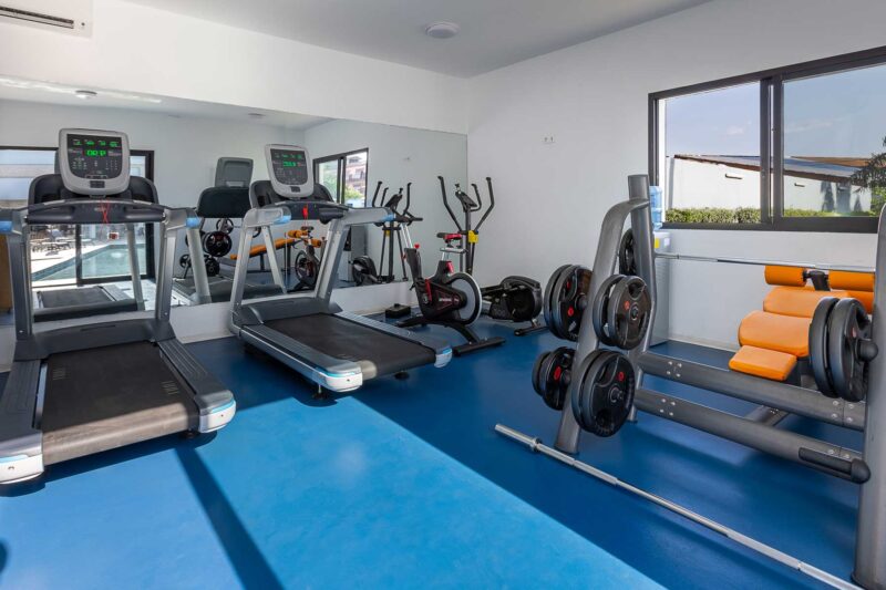 a gym with treadmills and a barbell rack