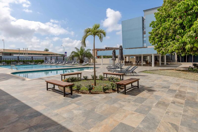 a large swimming pool surrounded by chairs and benches