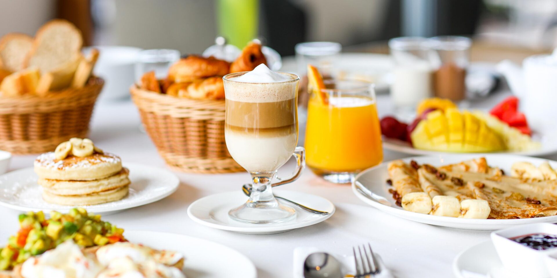 a table full of food and drinks including a cup of coffee