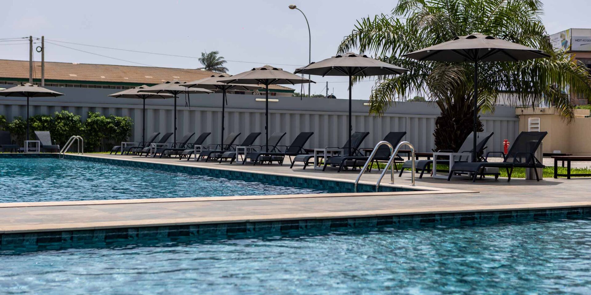 a swimming pool with chairs and umbrellas around it