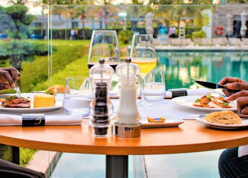 deux personnes sont assises à une table avec des assiettes de nourriture et des verres de vin