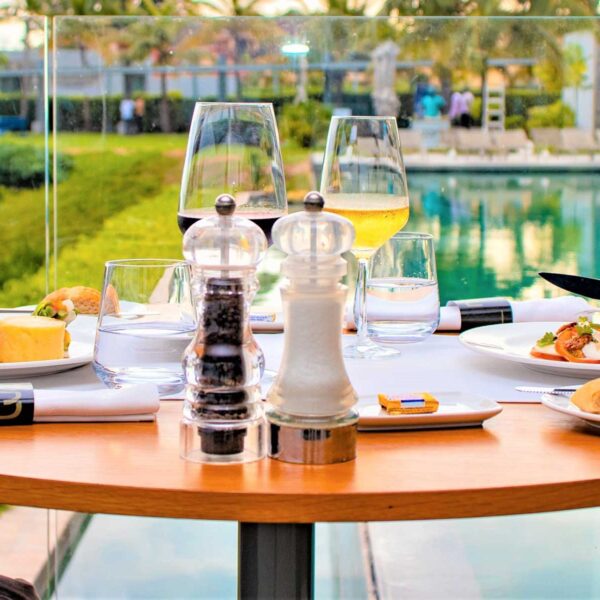 people sitting at a table with plates of food and glasses of wine