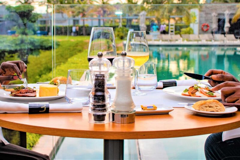 deux personnes sont assises à une table avec des assiettes de nourriture et des verres de vin