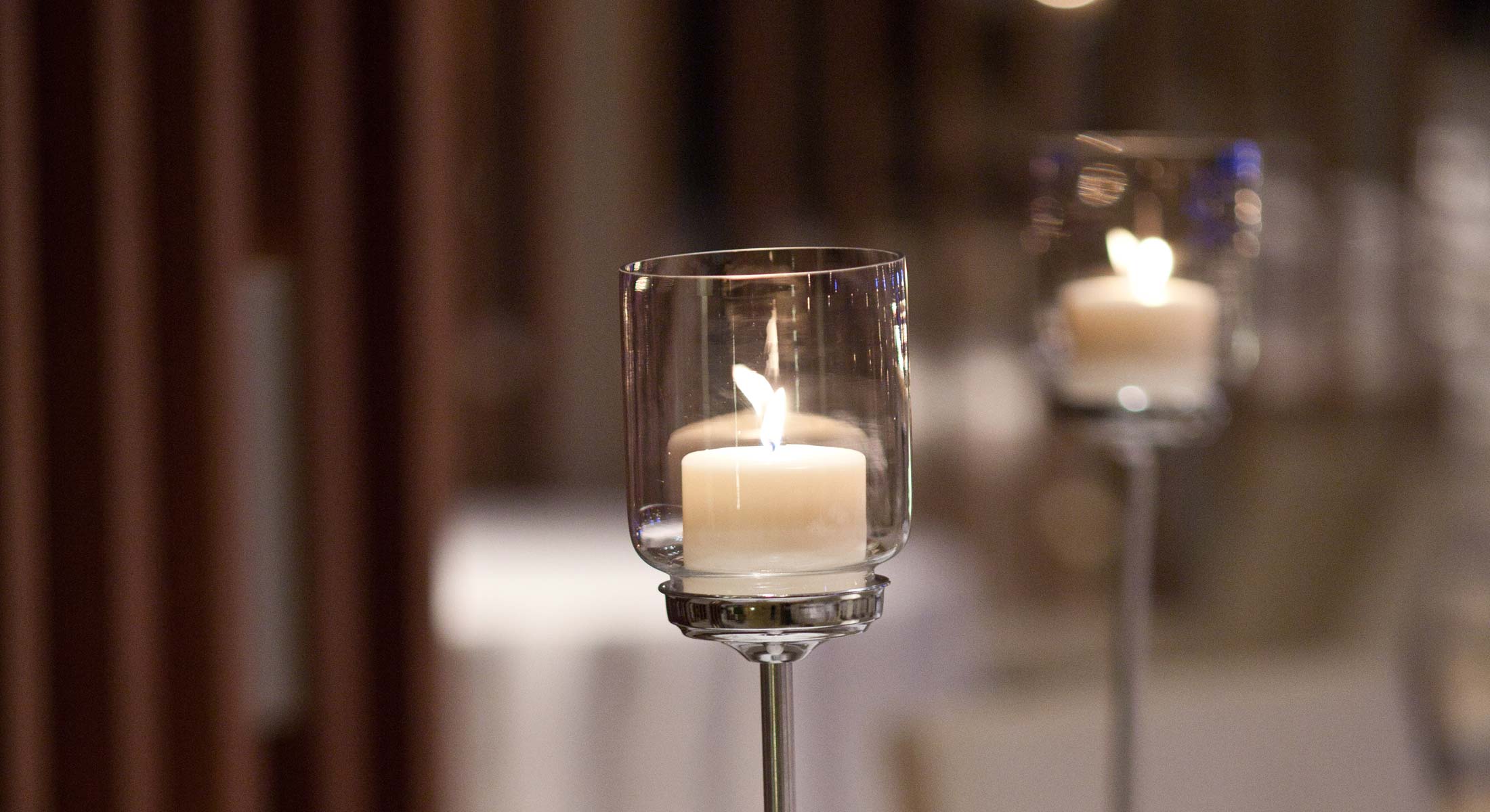 a candle is lit in a clear glass holder