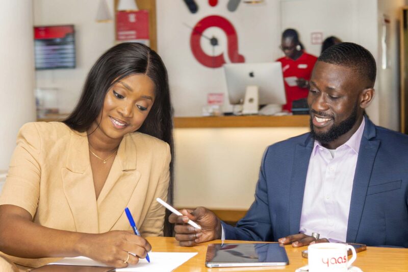 a man and a woman sit at a table with a cup that says yooh on it