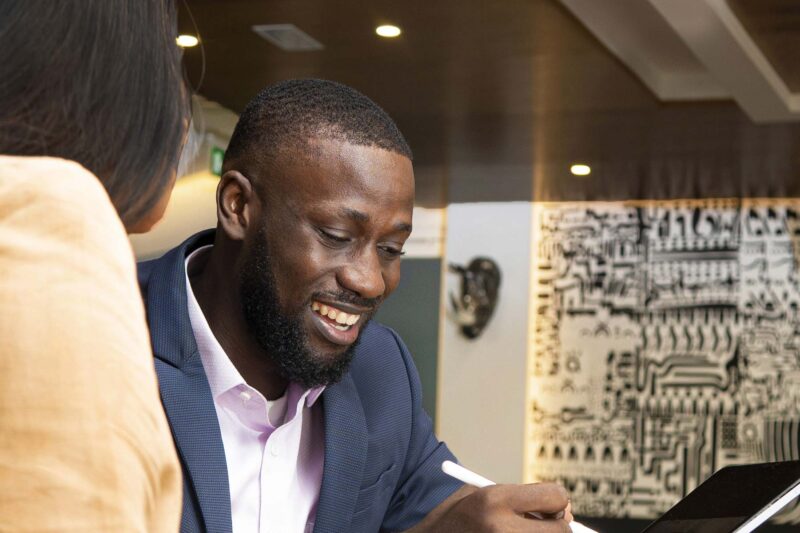 a man is smiling while looking at a tablet