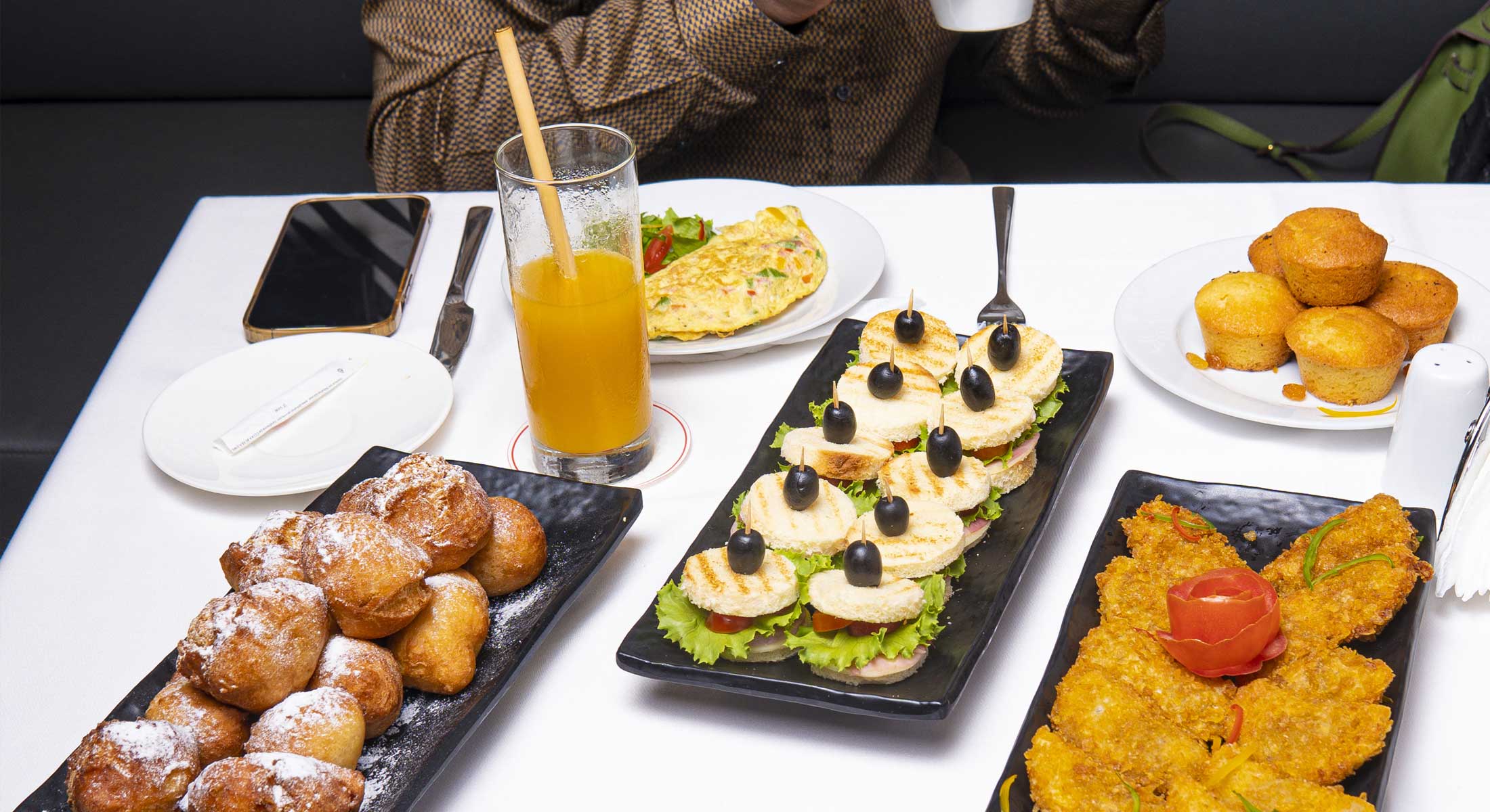 une table avec des assiettes de nourriture et un verre de jus d'orange