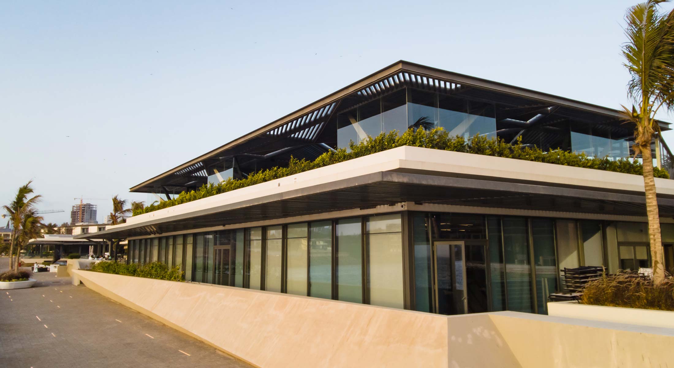 a large building with a lot of windows and plants on the roof