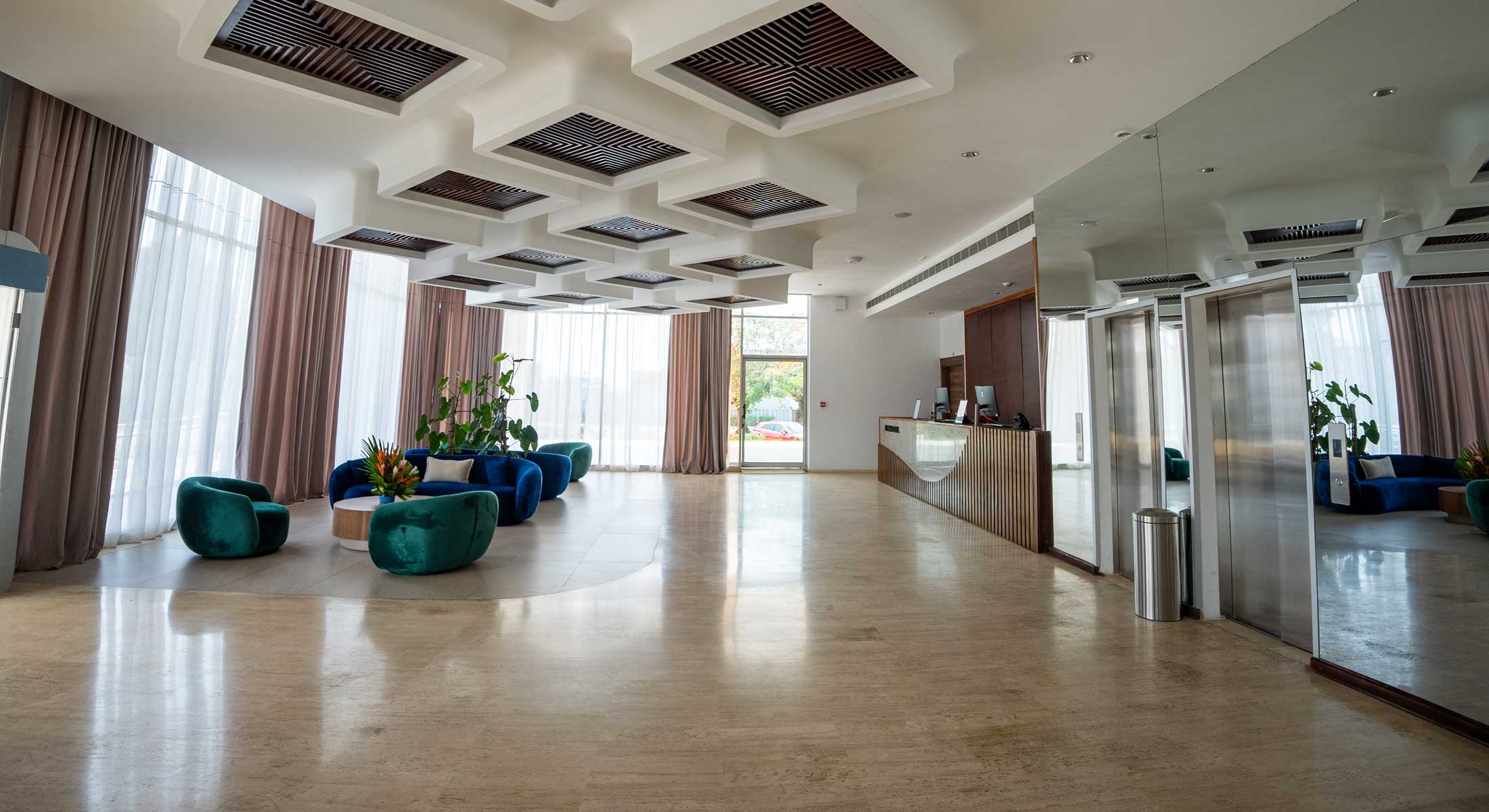 un hall d' hôtel avec des chaises bleues et un bureau