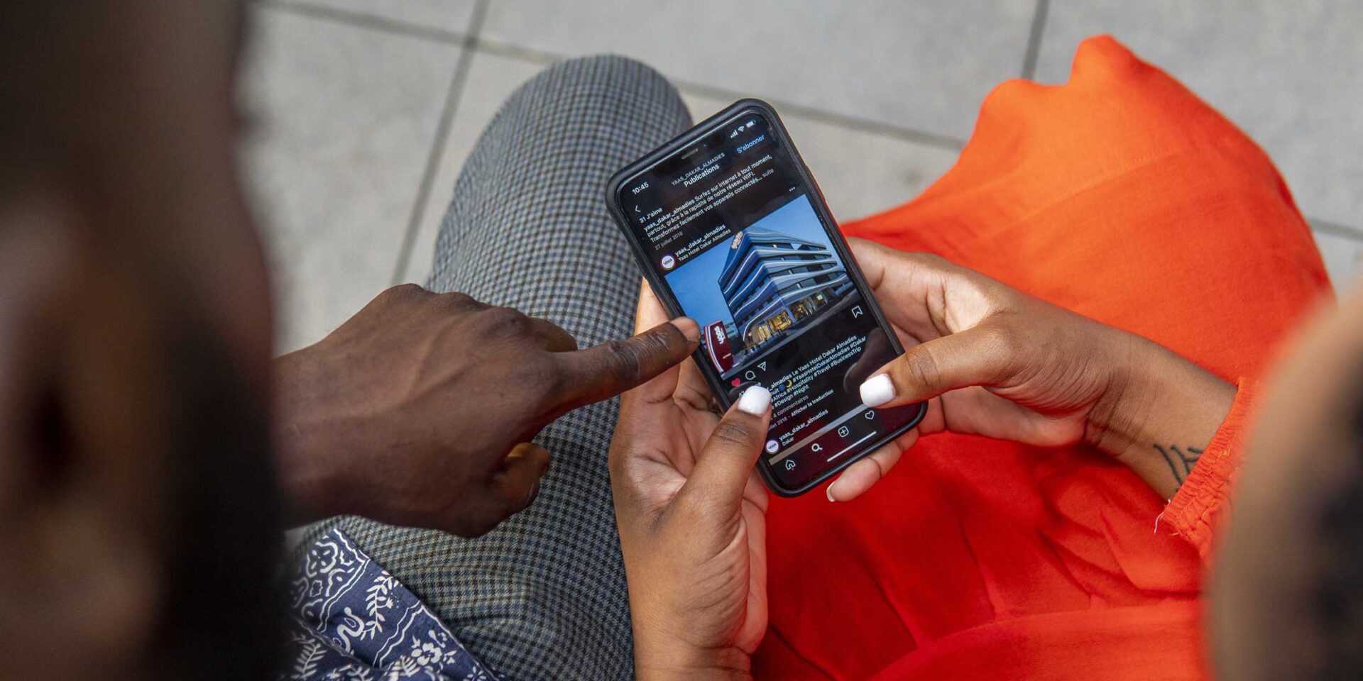 un homme et une femme regardent un téléphone portable