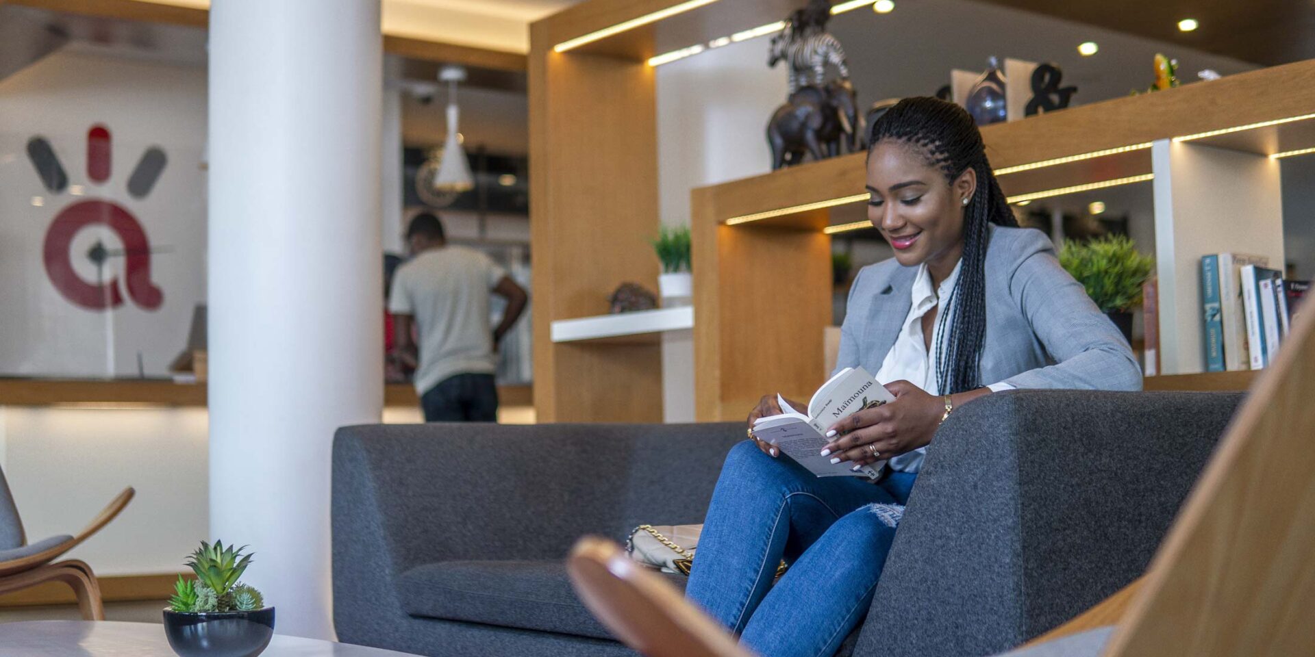 a woman sits on a couch reading a book