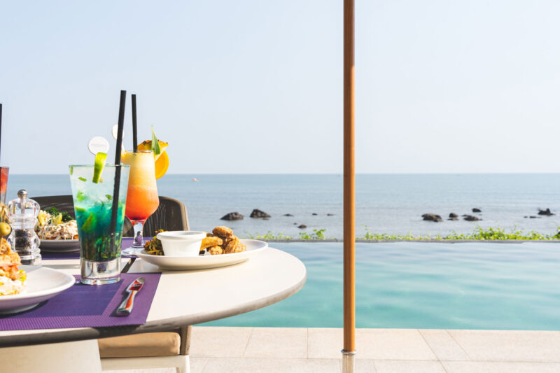 une table avec des plats et des boissons à côté d'une piscine