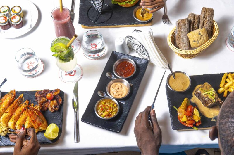 a table with plates of food and drinks and a basket of bread