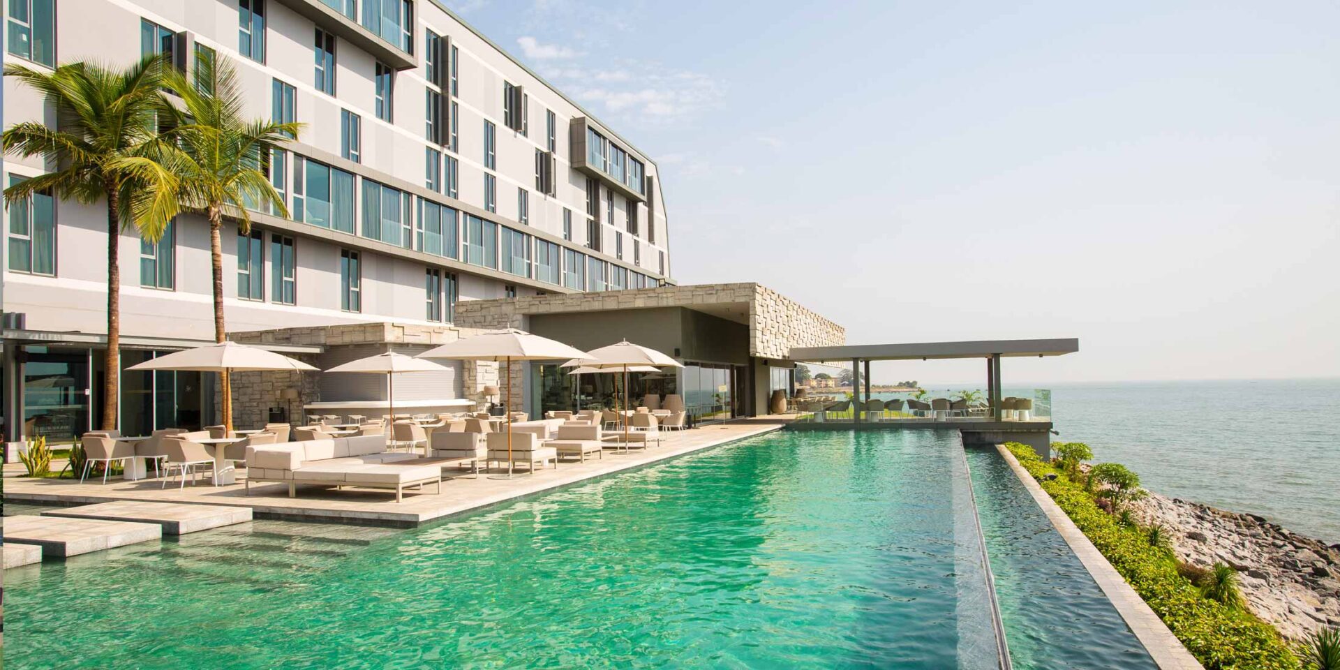 une grande piscine entourée d' un grand bâtiment avec vue sur l' océan