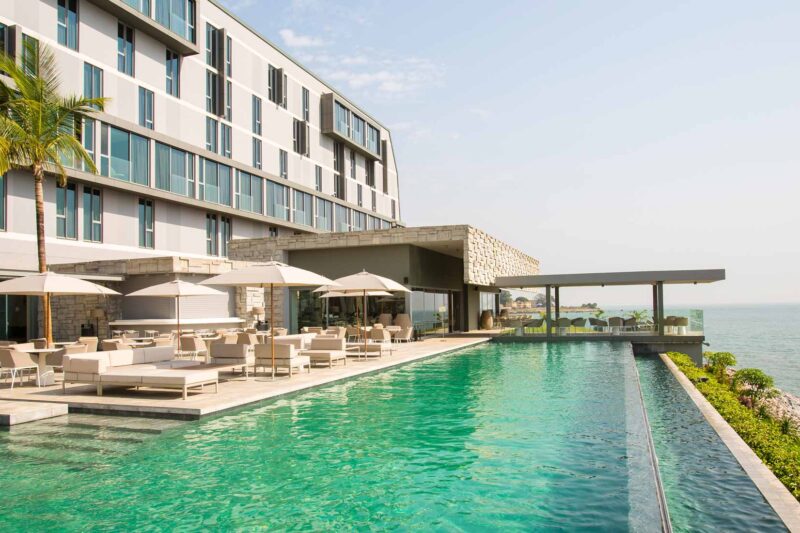 une grande piscine entourée d' un grand bâtiment avec vue sur l' océan