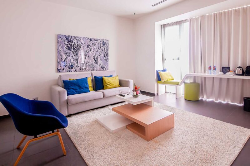 a living room with a white couch and blue chairs