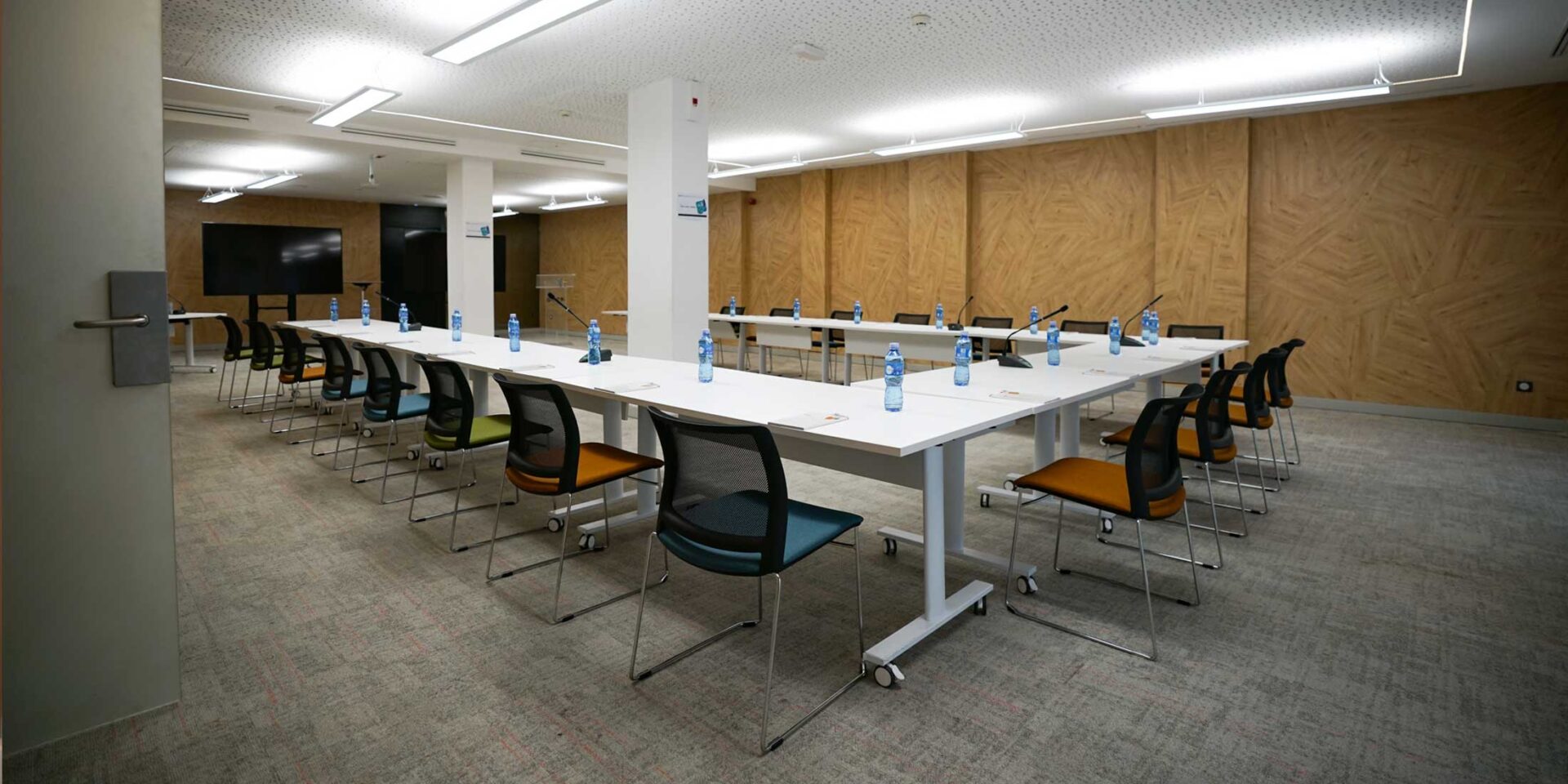 a conference room with u shaped tables and chairs