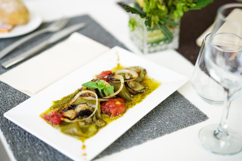 une assiette de nourriture est posée sur une table à côté d' un verre de vin