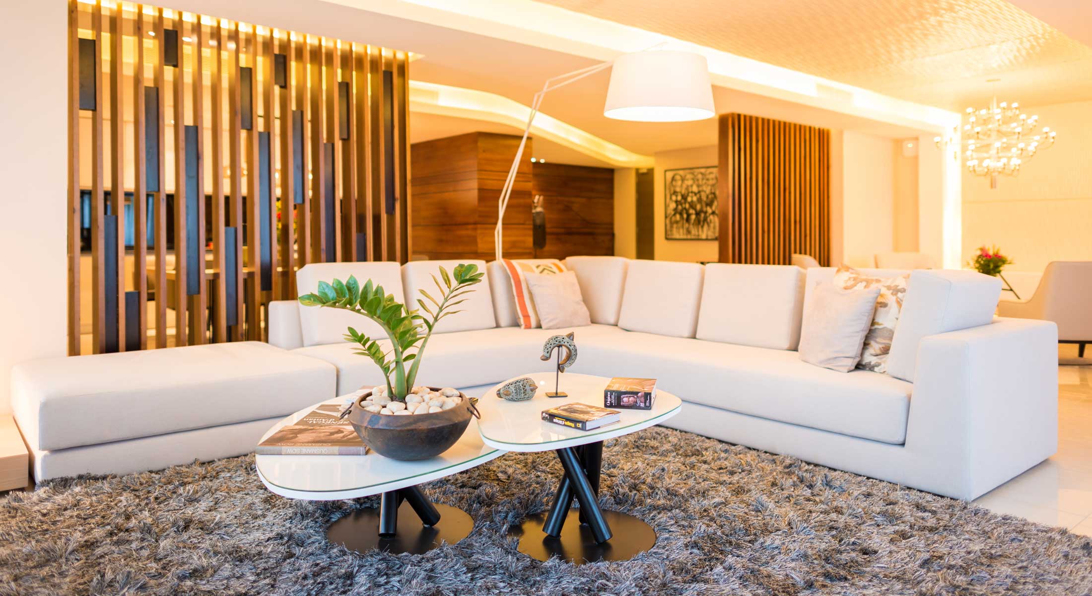 a living room with a white sectional couch and two tables