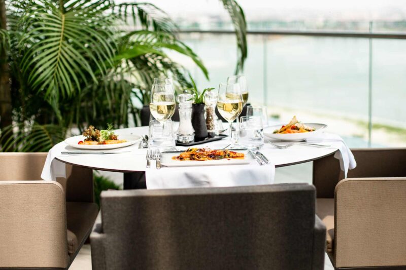 a table with plates of food and glasses of wine