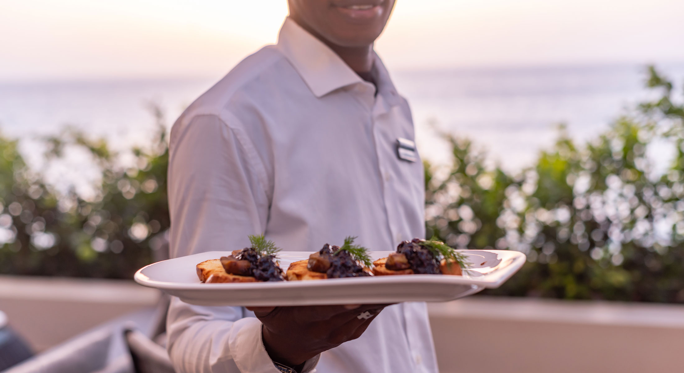 a man in a white shirt is holding a plate of food