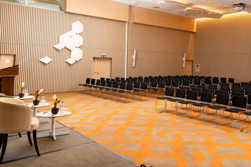 a large conference room with rows of chairs and tables