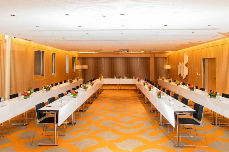 a conference room with long tables and chairs set up for a meeting