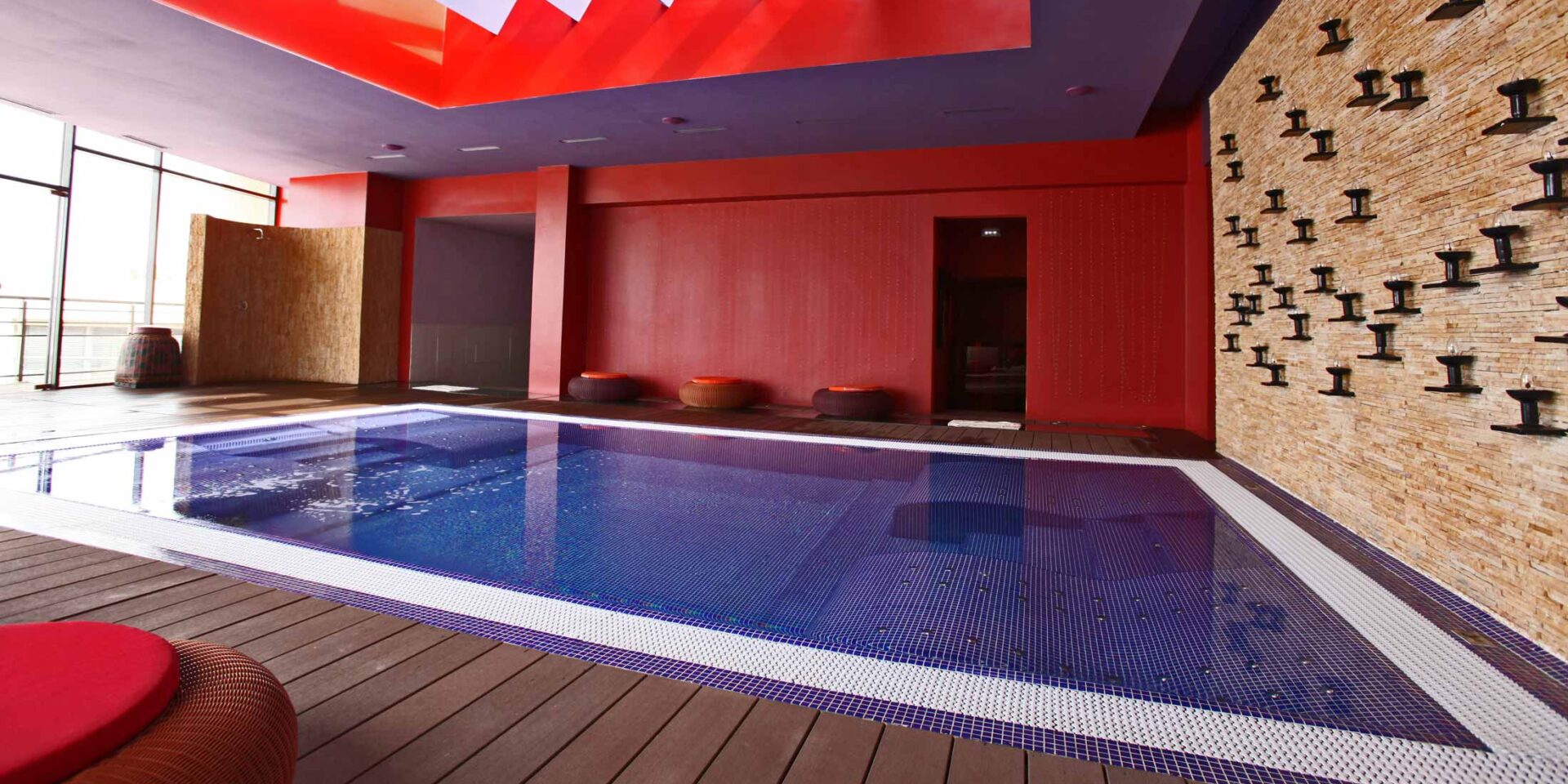 a swimming pool with a red wall and a purple ceiling