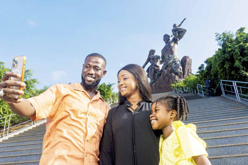 un homme et une femme prennent un selfie devant une statue