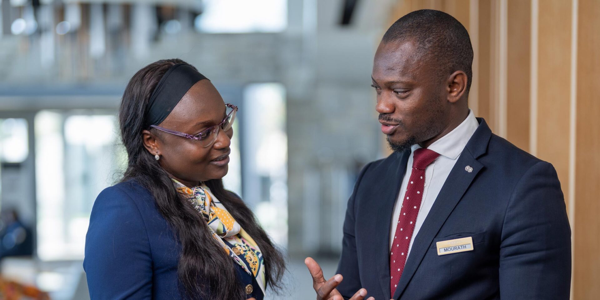 a man with a name tag that says security talks to a woman