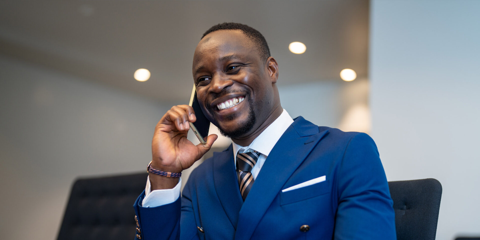 un homme en costume bleu parle sur un téléphone portable