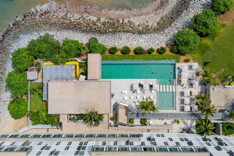 une vue aérienne d' un grand bâtiment avec une piscine à côté de l' océan