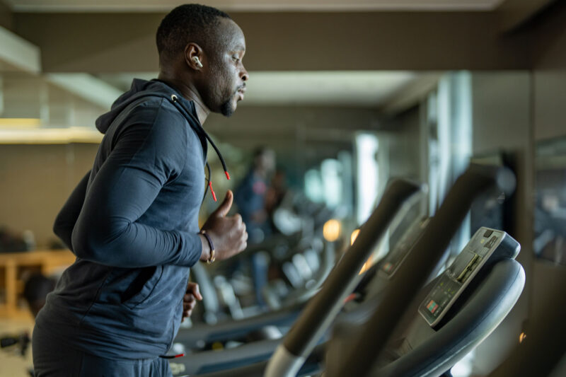 un homme court sur un tapis roulant dans une salle de sport