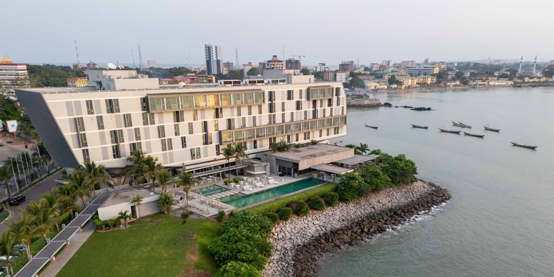 un grand bâtiment avec une piscine à côté de l' océan