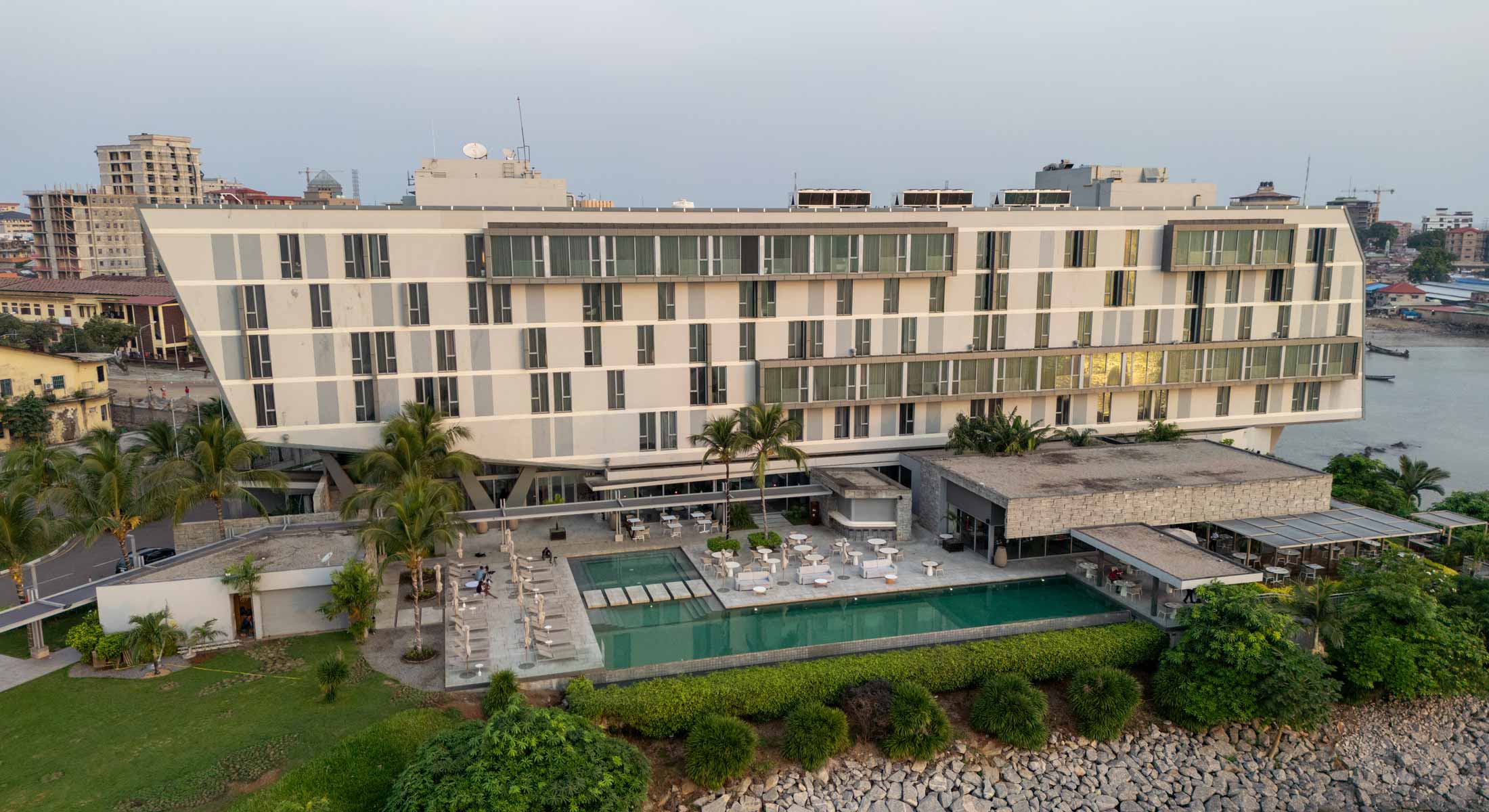 un grand bâtiment blanc avec une grande piscine au milieu