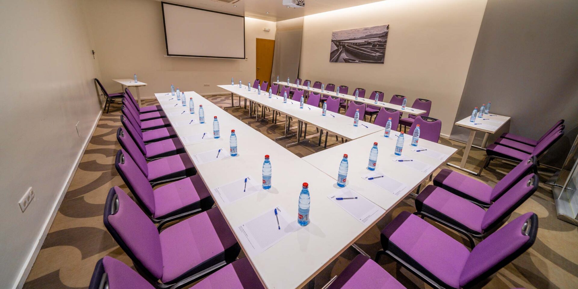 une salle de conférence avec des tables et des chaises violettes