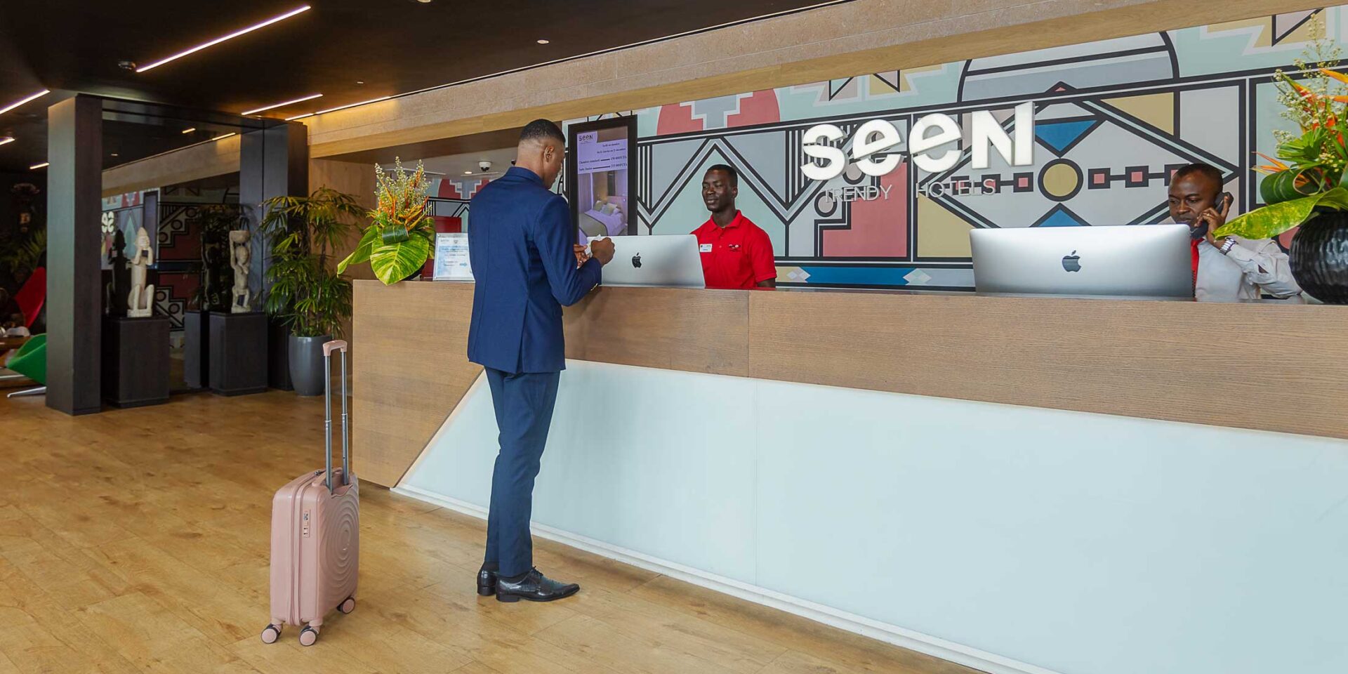 un homme avec une valise se tient à la réception d' un hôtel