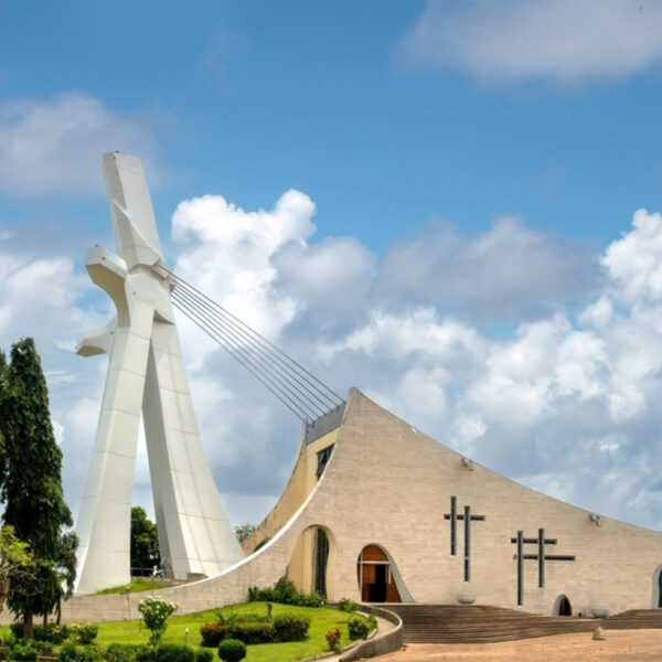 a large white building with a cross on the side