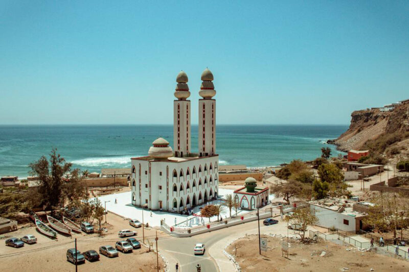 une grande mosquée blanche avec deux minarets à côté de l' océan